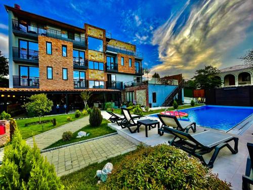 a building with a swimming pool next to a building at Boutique Hotel Kviria in Tʼelavi