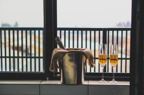 two glasses of wine sitting on a ledge next to a window at Boutique Hotel Kviria in Tʼelavi