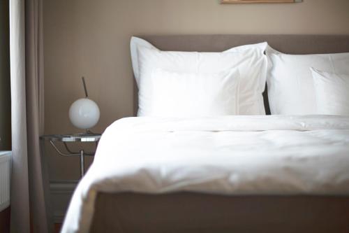 a white bed with a white comforter and pillows at The Duxiana Malmö in Malmö