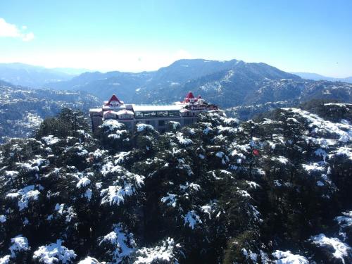 a building on top of a snow covered mountain at WelcomHeritage Elysium Resort & Spa in Shimla