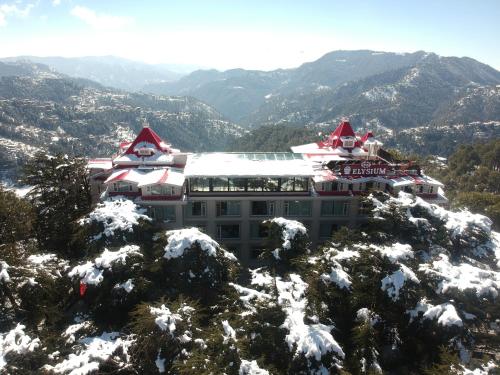 a building on top of a mountain in the snow at WelcomHeritage Elysium Resort & Spa in Shimla
