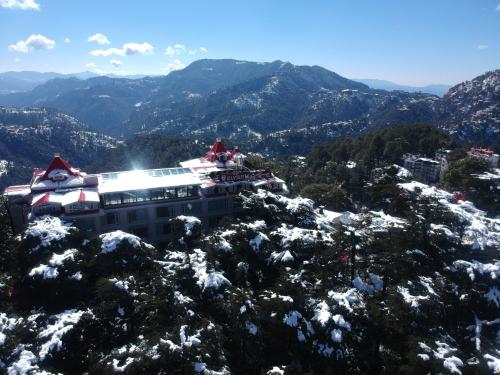a building on top of a snow covered mountain at WelcomHeritage Elysium Resort & Spa in Shimla