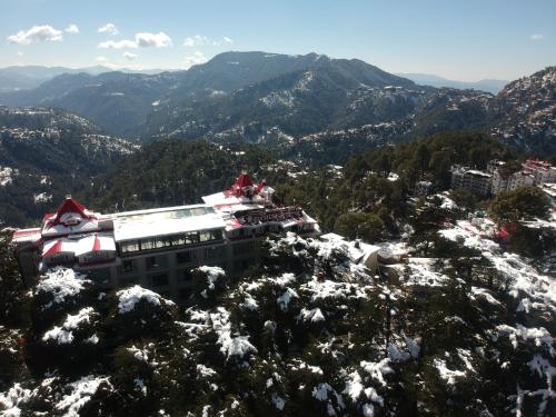 a building on top of a snow covered mountain at WelcomHeritage Elysium Resort & Spa in Shimla