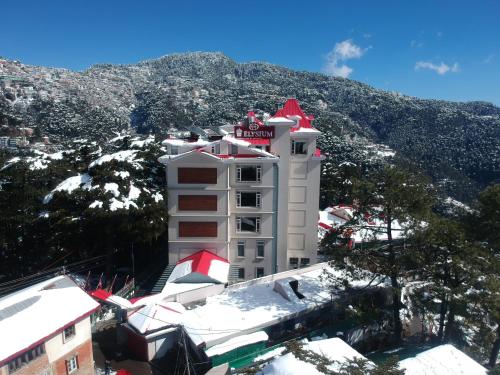 a white building with a red roof on a mountain at WelcomHeritage Elysium Resort & Spa in Shimla