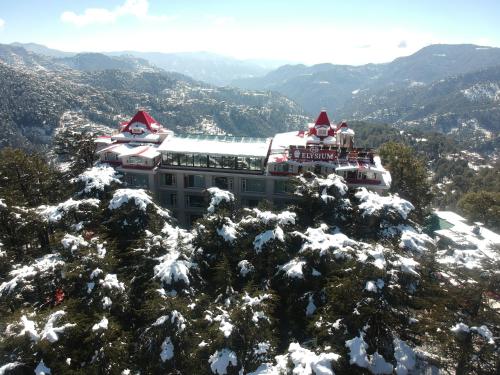 a building on top of a snow covered mountain at WelcomHeritage Elysium Resort & Spa in Shimla