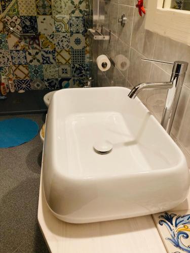 a white toilet in a bathroom with a sink at The Flowers' House in Potenza