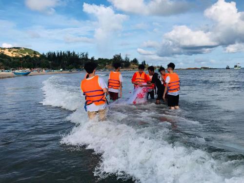 a group of people in orange vests in the water at Stop And Go Lang Chai Boutique Resort in Phan Thiet
