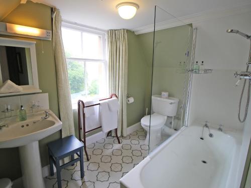 a bathroom with a tub and a toilet and a sink at Viewfield House in Portree