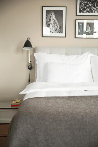 a bedroom with a white bed with pictures on the wall at TwentySix in Malmö