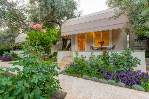 a home with a garden with flowers and plants at Gurel Garden House in Kucukkuyu