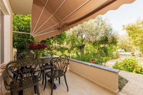 a balcony with a table and chairs and an umbrella at Gurel Garden House in Kucukkuyu