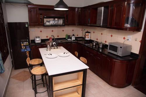 a kitchen with wooden cabinets and a white counter top at Eden Westlake Hotel in Hanoi