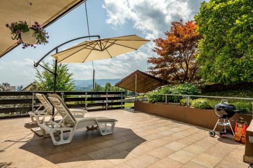 two chairs and an umbrella on a patio at Apartment Valy - Free Bikes, Relaxing Terrace & Near Bled in Bled