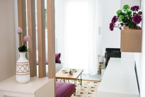 a living room with a vase of flowers on a table at Onar Village Luxury Apartments in Kavala