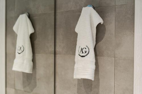 two white towels are hanging in a shower at Onar Village Luxury Apartments in Kavala