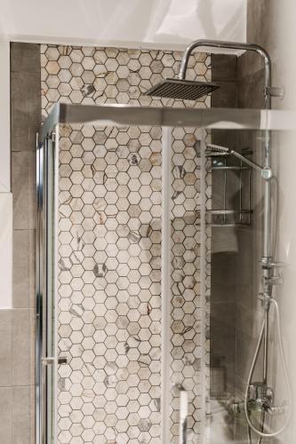 a shower in a bathroom with a tile wall at Onar Village Luxury Apartments in Kavala