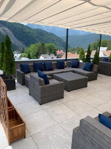 a patio with couches and blue pillows on a roof at HOTEL CARPAT INN in Azuga
