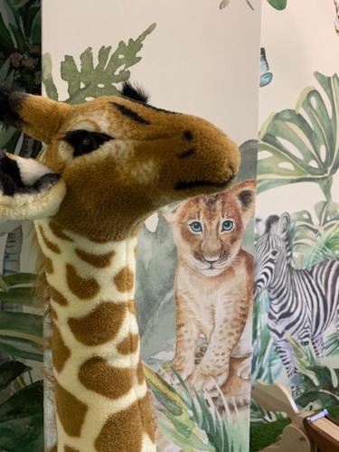 a giraffe standing next to a picture of a tiger at HOTEL CARPAT INN in Azuga