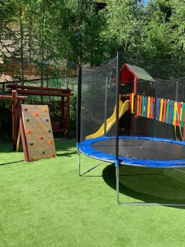 a playground with a slide and a play equipment at HOTEL CARPAT INN in Azuga
