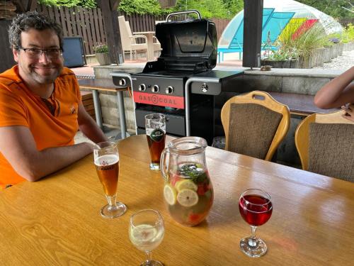 a man sitting at a table with glasses of beer at Penzion Alfa in Železná Ruda