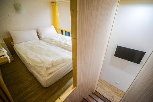 a small bed in a small room with a mirror at 綠蠵龜潛水住宿 in Xiaoliuqiu