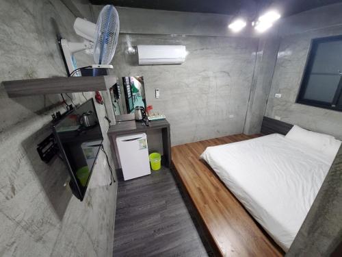 a small room with a bed and a small refrigerator at 綠蠵龜潛水住宿 in Xiaoliuqiu