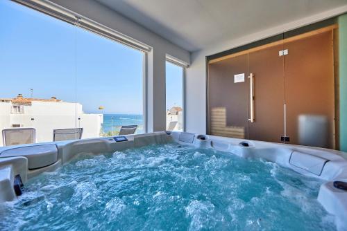 wanna z hydromasażem w pokoju z widokiem na ocean w obiekcie Hotel Ilusion Moreyo - Adults Only w mieście Cala Bona