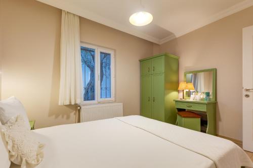 a bedroom with a white bed and a green cabinet at Gurel Garden House in Kucukkuyu