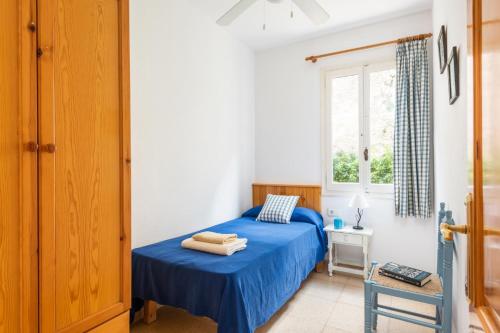 a bedroom with a blue bed and a window at Villa Las Mariposas by Villa Plus in Es Mercadal