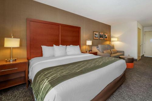 a hotel room with a large bed and a chair at Comfort Inn Humboldt Bay in Eureka