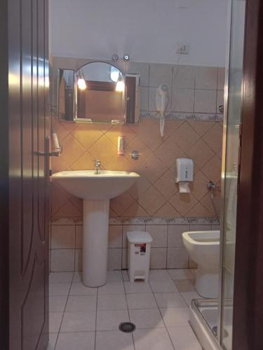 a bathroom with a sink and a toilet at Drini Hotel in Durrës
