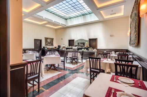 a dining room with tables and chairs and a skylight at Hotel Diocleziano in Rome