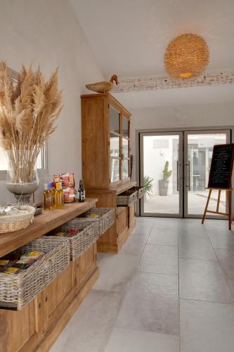 a kitchen with wooden cabinets and a counter with food at Lodge Sainte Helene Adult only in Saintes-Maries-de-la-Mer
