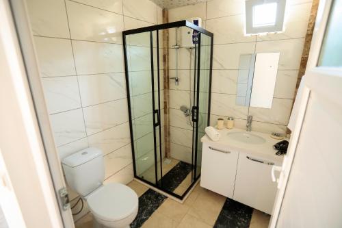 een badkamer met een douche, een toilet en een wastafel bij Linaden Apart in Kumluca