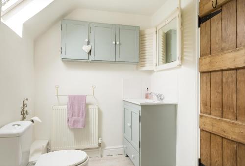 a bathroom with a toilet and a sink at Hope Cottage in Quenington