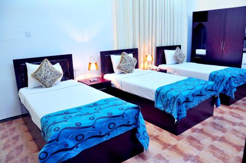 Un pat sau paturi într-o cameră la Majan Guest House L.L.C.