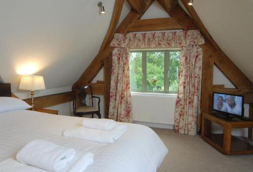 a bedroom with a white bed and a window at Hirons Piece in Weston Subedge