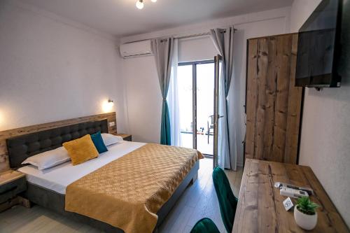 a hotel room with a bed and a table at Casa AdiMan in Vama Veche