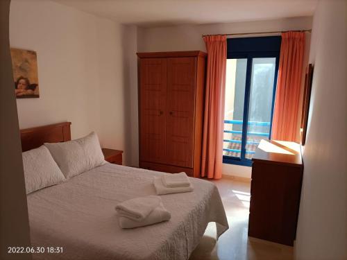 ein Schlafzimmer mit einem Bett mit zwei Handtüchern darauf in der Unterkunft Apartamento Puerto - Sol. in Fuengirola