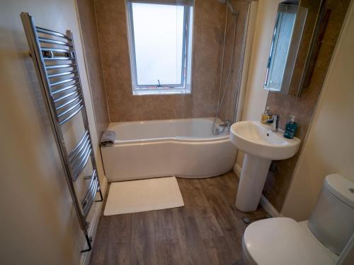a bathroom with a tub and a sink and a toilet at Pass the Keys Stunning 1 bedroom Penthouse in Nottm City Centre in Nottingham