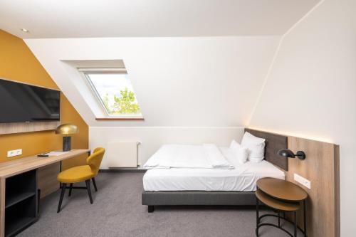 Hotel Rheinischer Hof في دينكلاغه: غرفة نوم بسرير ومكتب وتلفزيون