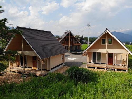 two small houses are sitting in a field at Log Cottage 白馬KIITOS in Hakuba