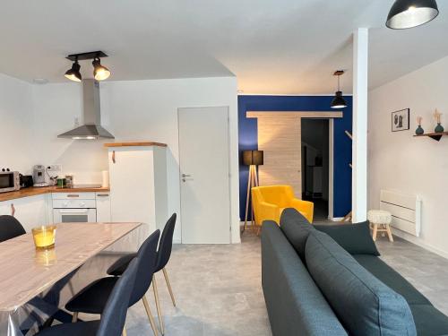 Il comprend un salon et une cuisine avec une table et un canapé. dans l'établissement L'Hypercentral, à Cauterets