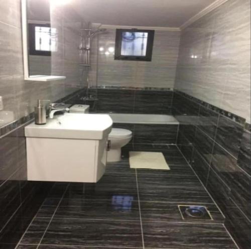 a bathroom with a toilet and a sink and a tub at The Guesthouse South Lebanon - privacy & luxury 