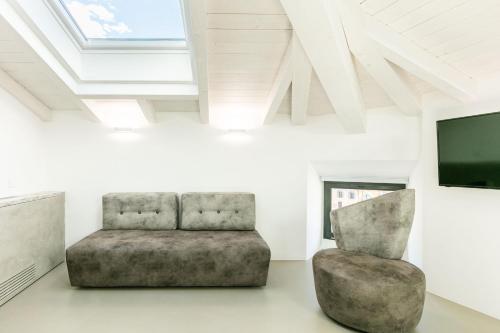 a living room with a chair and a tv at DOMUS CAVOUR Rooms&Suites in Tirano
