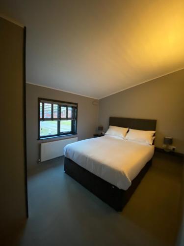 a bedroom with a large white bed and a window at L19 - Penrhyn Spa Lodge with Hot Tub in Bethesda