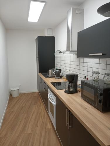 eine Küche mit einer hölzernen Arbeitsplatte in einem Zimmer in der Unterkunft Thuir: superbe appartement in Thuir