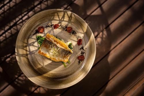 a plate of food with a sandwich on it at Eden Hotel by Maistra Collection in Rovinj