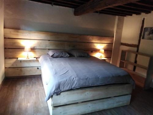 a bedroom with a bed with two lights on at Le chant de l Aisne in Érezée