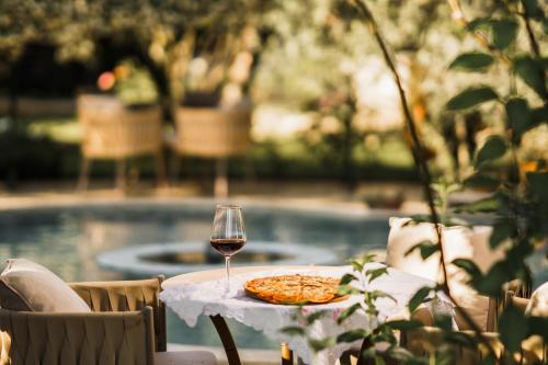 a table with a pizza and a glass of wine at Gurel Garden House in Kucukkuyu